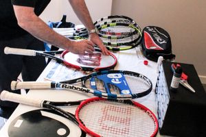 Peter Dalton applying a logo design to the centre of a racket