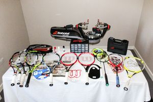 A wide range of rackets, racket accessories, and racket stringing tools, arranged on a table